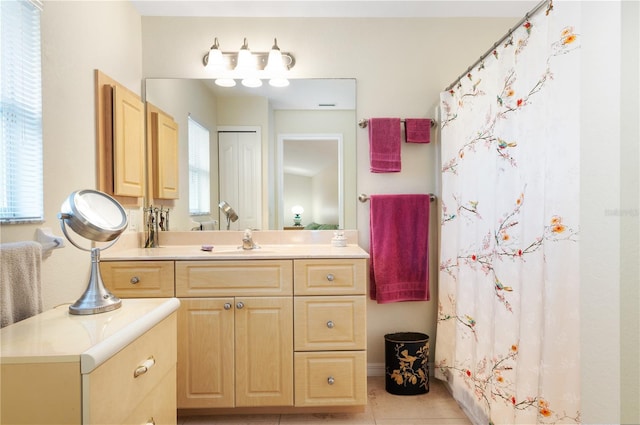 bathroom with tile patterned flooring, vanity, and a wealth of natural light