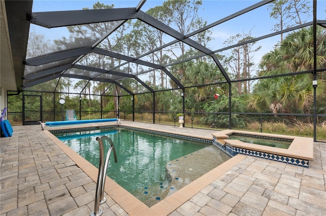 view of swimming pool featuring a lanai, a patio area, and an in ground hot tub