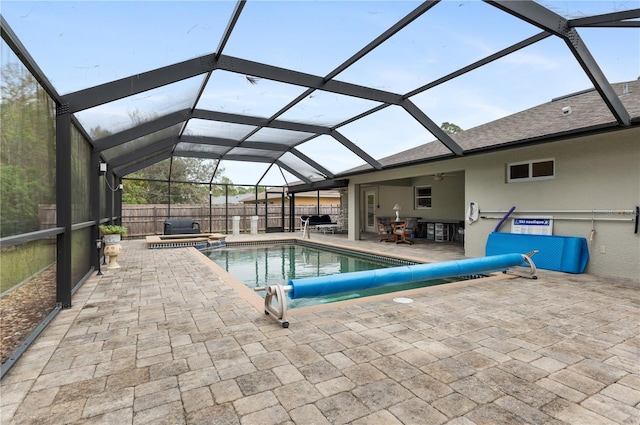 view of swimming pool featuring glass enclosure, an in ground hot tub, ceiling fan, and a patio