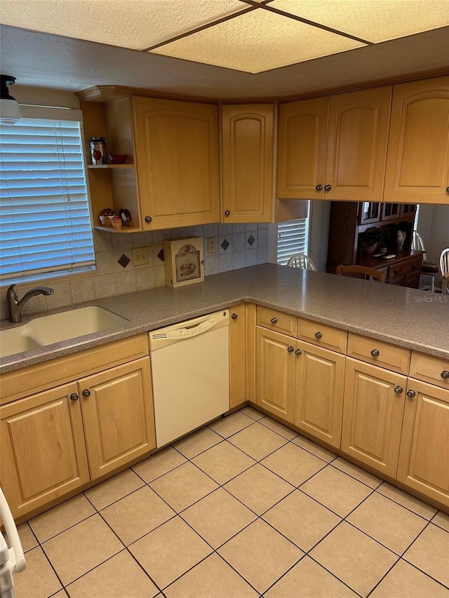 kitchen with white dishwasher, light tile patterned flooring, and sink