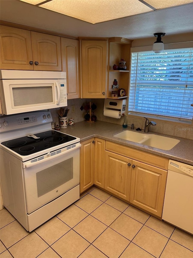 kitchen featuring sink, light tile patterned floors, white appliances, and light brown cabinets