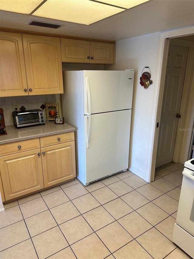 kitchen with decorative backsplash, light brown cabinetry, white appliances, and light tile patterned floors