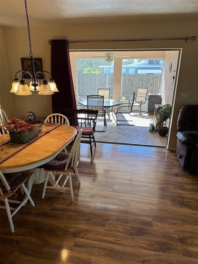 dining area featuring dark hardwood / wood-style floors, plenty of natural light, a textured ceiling, and a chandelier