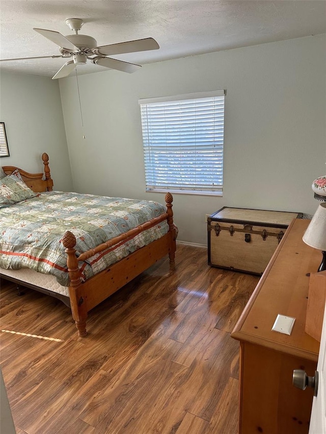 bedroom featuring ceiling fan, dark wood-type flooring, and a textured ceiling