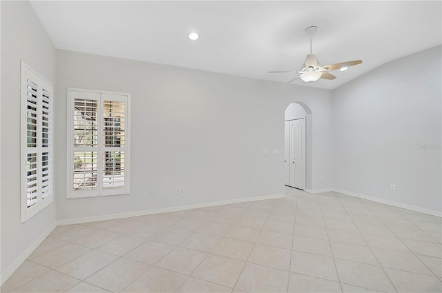 tiled spare room featuring vaulted ceiling and ceiling fan