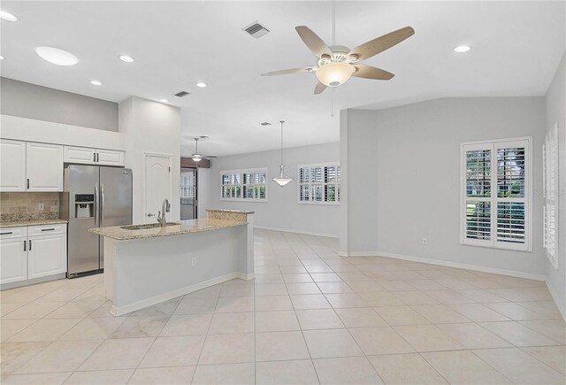 4575 Cancello Grande Ave, Venice, FL 34293 - kitchen with tasteful backsplash, sink, white cabinets, stainless steel fridge, and light stone counters