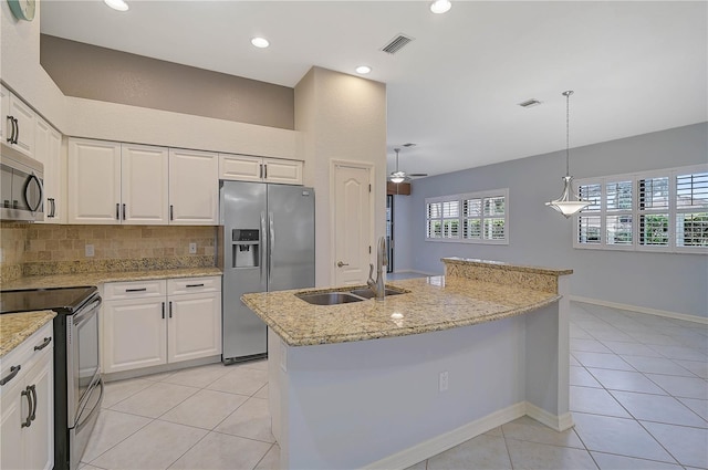 4575 Cancello Grande Ave, Venice, FL 34293 - kitchen with a kitchen island with sink, white cabinetry, and stainless steel appliances