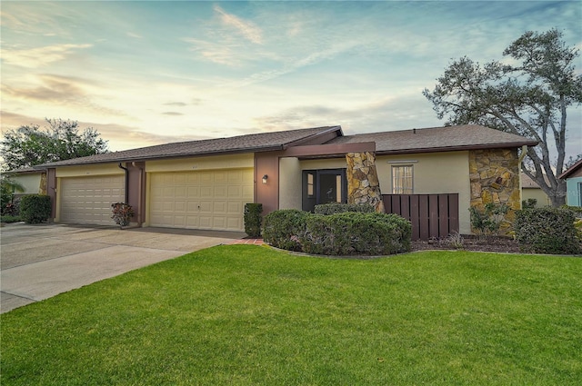 ranch-style home with a garage and a lawn