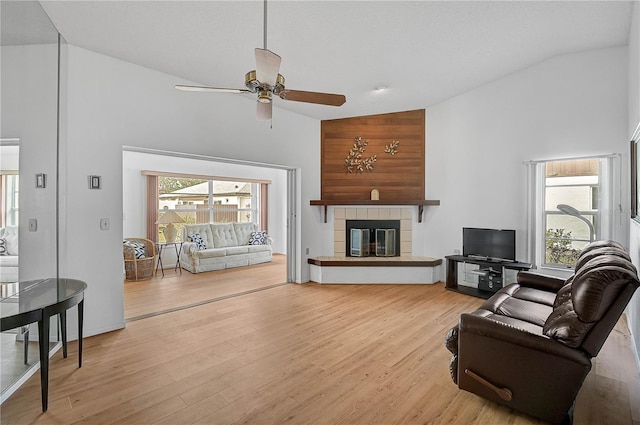 living room featuring ceiling fan, high vaulted ceiling, and light wood-type flooring