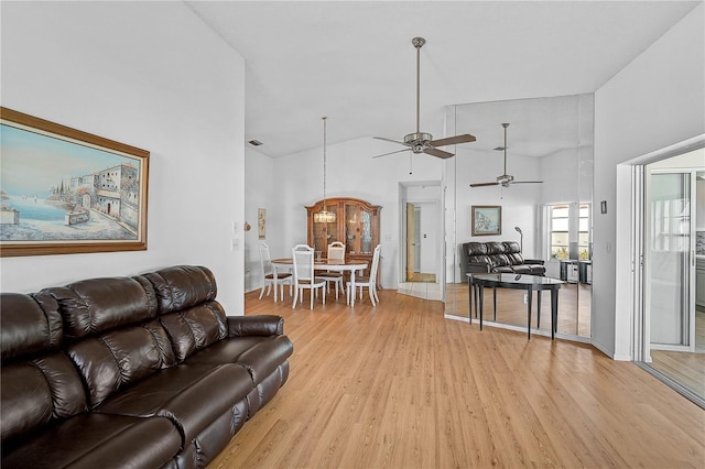 living room with high vaulted ceiling, ceiling fan, and light hardwood / wood-style floors