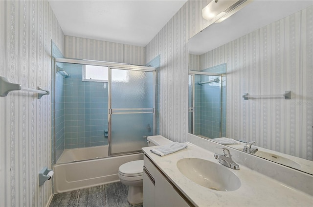 full bathroom featuring toilet, wood-type flooring, vanity, and shower / bath combination with glass door