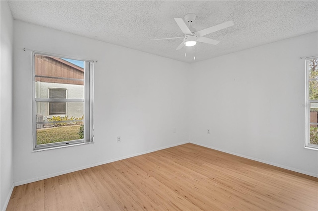 empty room featuring light wood-type flooring, ceiling fan, and a textured ceiling