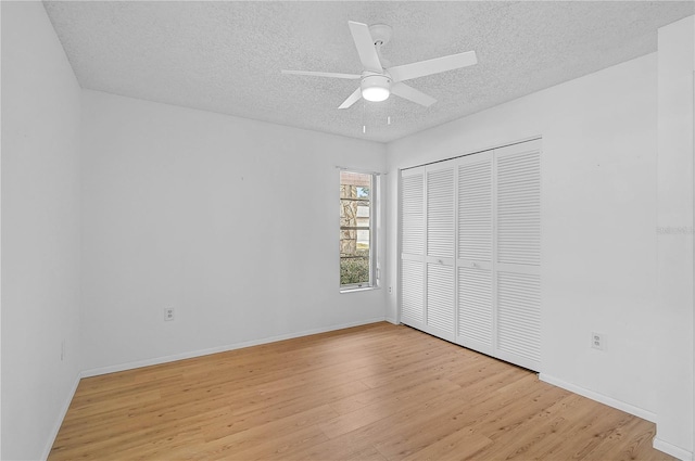 unfurnished bedroom featuring ceiling fan, light hardwood / wood-style floors, a textured ceiling, and a closet