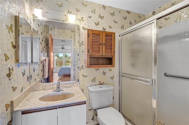 bathroom featuring toilet, ceiling fan, walk in shower, and vanity