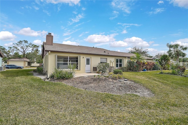 rear view of house with a lawn and a patio