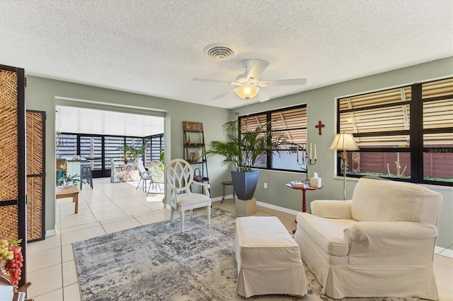 tiled living room with ceiling fan and a textured ceiling