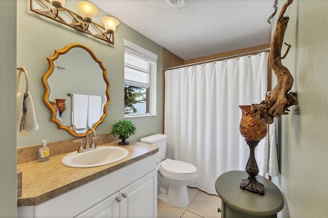 bathroom with tile patterned flooring, vanity, toilet, and a textured ceiling