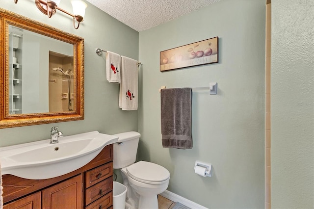 bathroom with vanity, a textured ceiling, and toilet