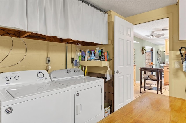 clothes washing area featuring ceiling fan, washing machine and clothes dryer, a textured ceiling, and light tile patterned floors