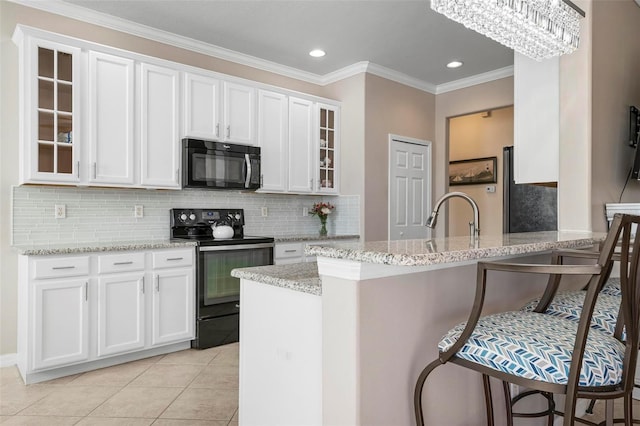 kitchen with black appliances and white cabinetry