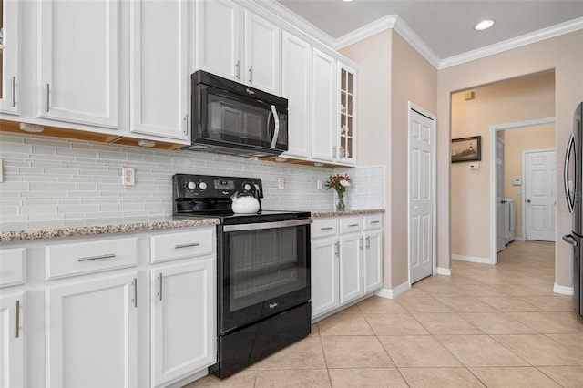 kitchen featuring light stone countertops, white cabinetry, light tile patterned flooring, black appliances, and ornamental molding