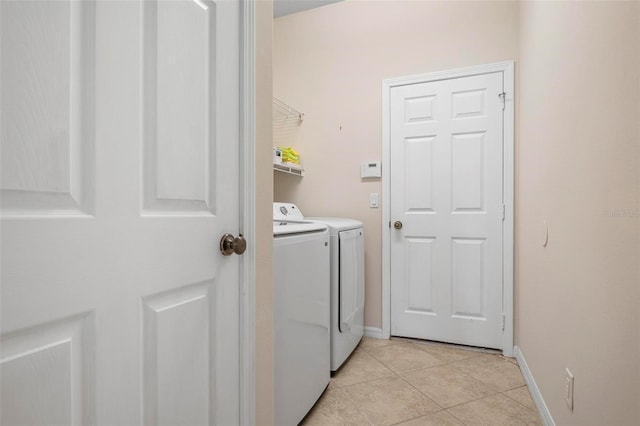 clothes washing area featuring washing machine and dryer and light tile patterned flooring