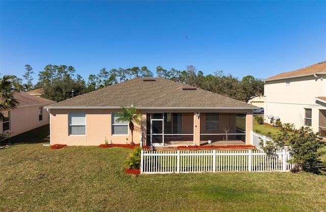 rear view of house featuring a sunroom and a yard