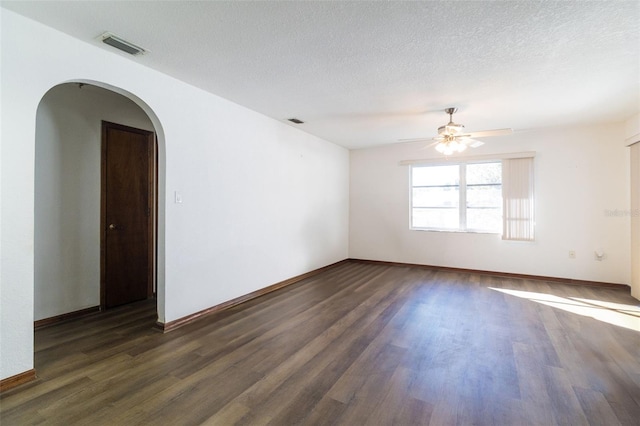 empty room with ceiling fan, dark hardwood / wood-style flooring, and a textured ceiling