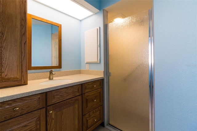 bathroom with vanity and a shower with door