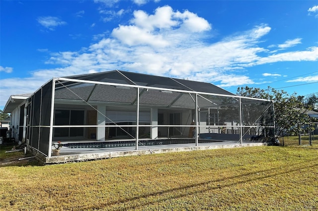 rear view of property with a lawn and glass enclosure