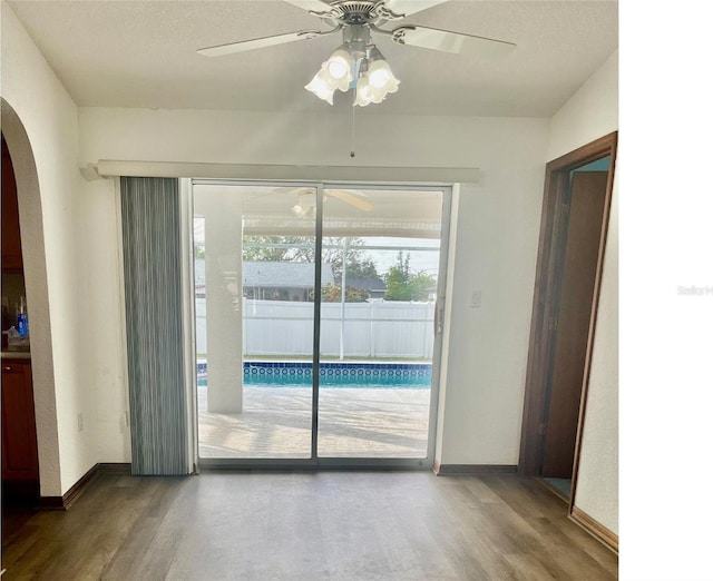 doorway featuring ceiling fan and hardwood / wood-style floors