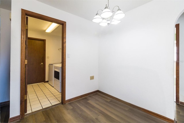 unfurnished dining area featuring light hardwood / wood-style flooring, a notable chandelier, and independent washer and dryer