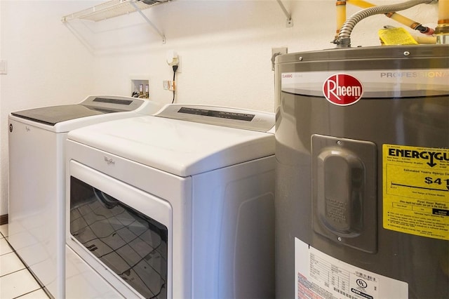 laundry area with electric water heater, light tile patterned floors, and washing machine and clothes dryer