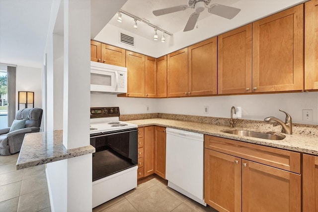 kitchen featuring light stone countertops, sink, ceiling fan, white appliances, and light tile patterned floors