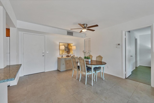 dining space with ceiling fan and light tile patterned flooring