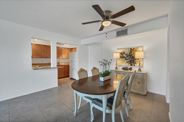 dining space with ceiling fan, sink, and light tile patterned flooring