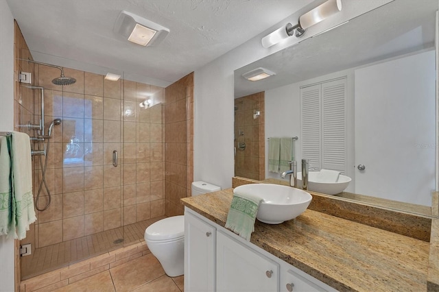 bathroom featuring an enclosed shower, a textured ceiling, vanity, tile patterned flooring, and toilet