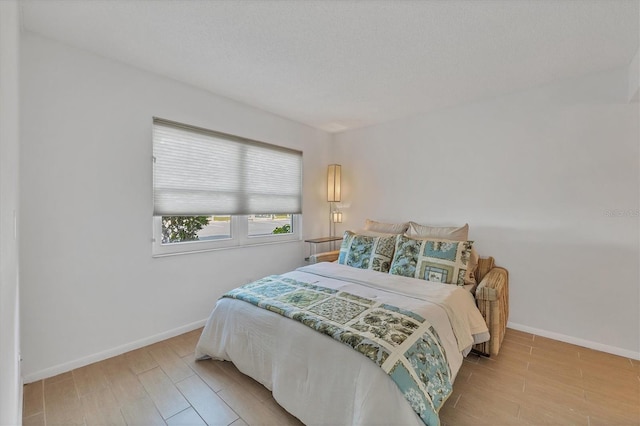 bedroom with light wood-type flooring and a textured ceiling