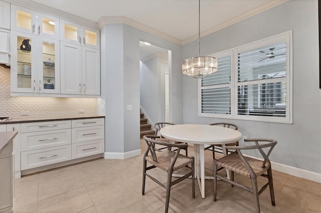 tiled dining room featuring crown molding