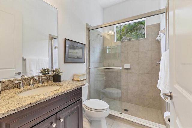 bathroom with an enclosed shower, vanity, toilet, and tile patterned flooring