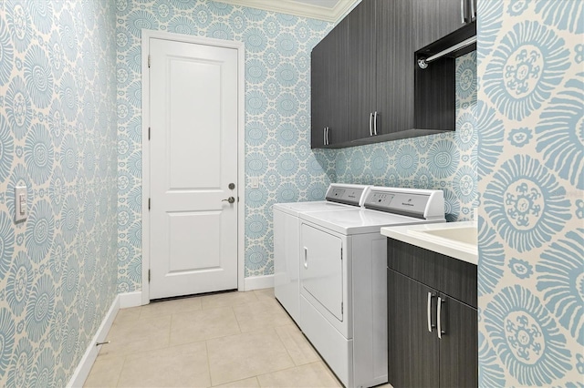 laundry area featuring cabinets, washing machine and clothes dryer, crown molding, and light tile patterned flooring