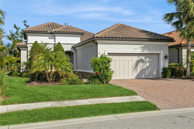 mediterranean / spanish house featuring a garage and a front yard