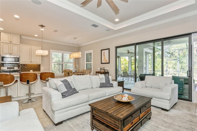 living room featuring ceiling fan, a wealth of natural light, light tile patterned flooring, and crown molding