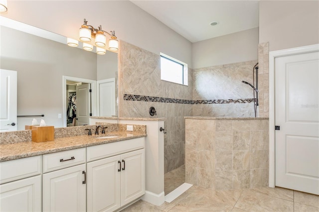 bathroom featuring vanity, tile patterned flooring, and tiled shower