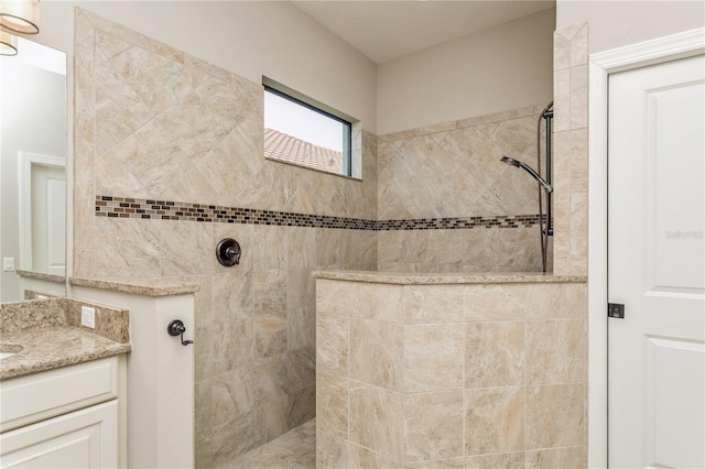 bathroom with vanity and tiled shower