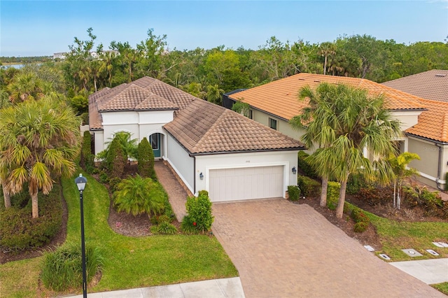 mediterranean / spanish home with a front yard and a garage