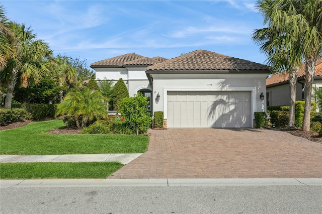 mediterranean / spanish house featuring a front lawn and a garage