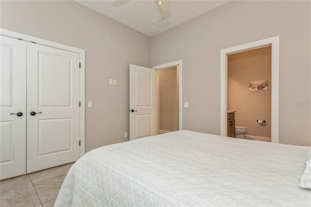 tiled bedroom featuring ceiling fan, a closet, and ensuite bathroom