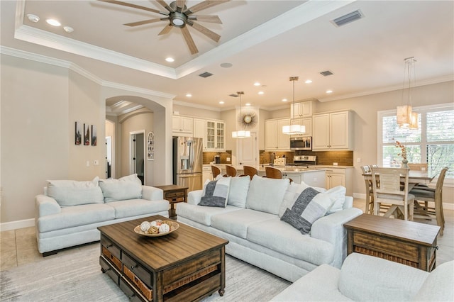 living room featuring ceiling fan, ornamental molding, and light tile patterned flooring