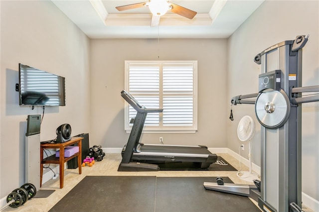 exercise room featuring ceiling fan, a tray ceiling, and crown molding